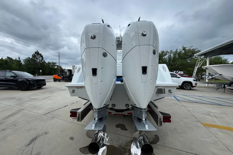 Slide: The Image of 2026 Invincible 33 Open Fisherman boat with dual outboard engines in a parking lot. - 14