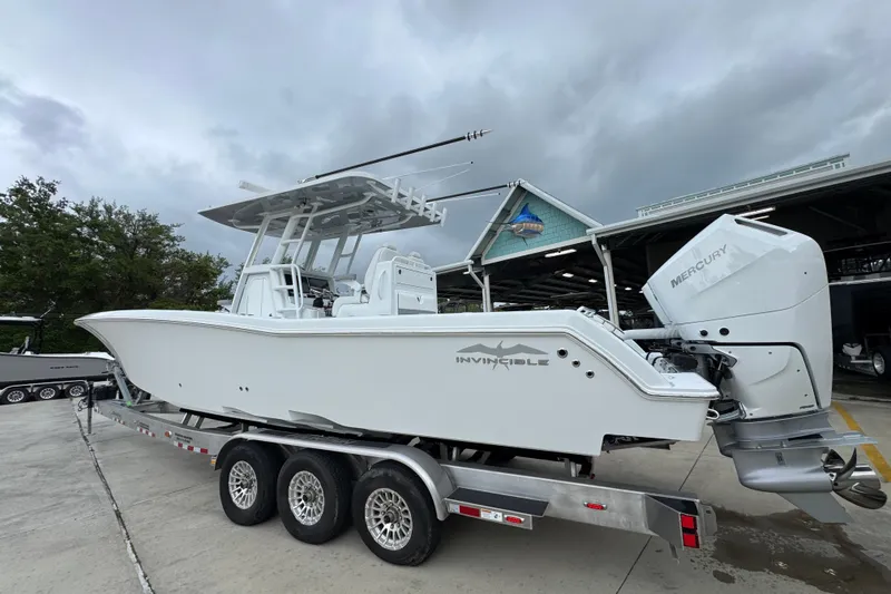 Slide: The Image of 2026 Invincible 33 Open Fisherman boat on trailer, featuring Mercury engines. - 16