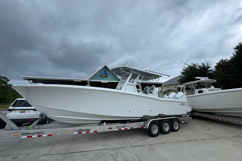 Slide: The Image of 2026 Invincible 33 Open Fisherman boat on trailer, parked outdoors under cloudy sky. - 2