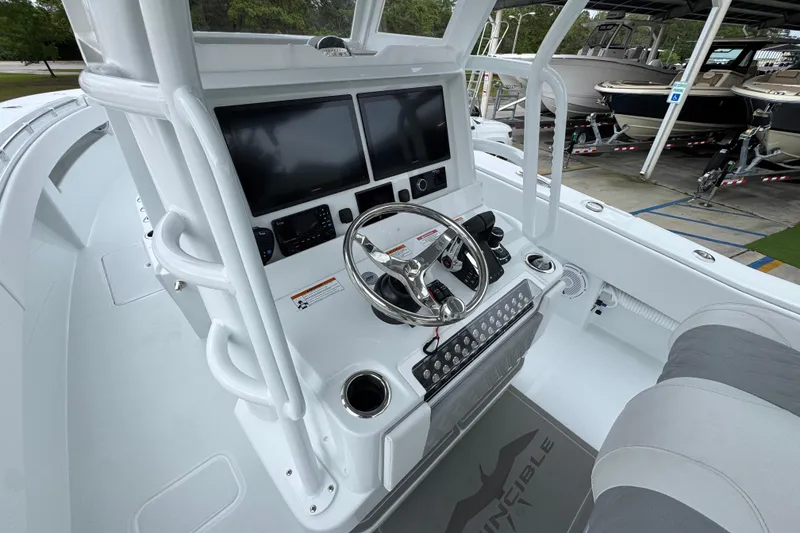 Slide: The Image of 2026 Invincible 33 Open Fisherman boat dashboard with dual screens and steering wheel. - 31