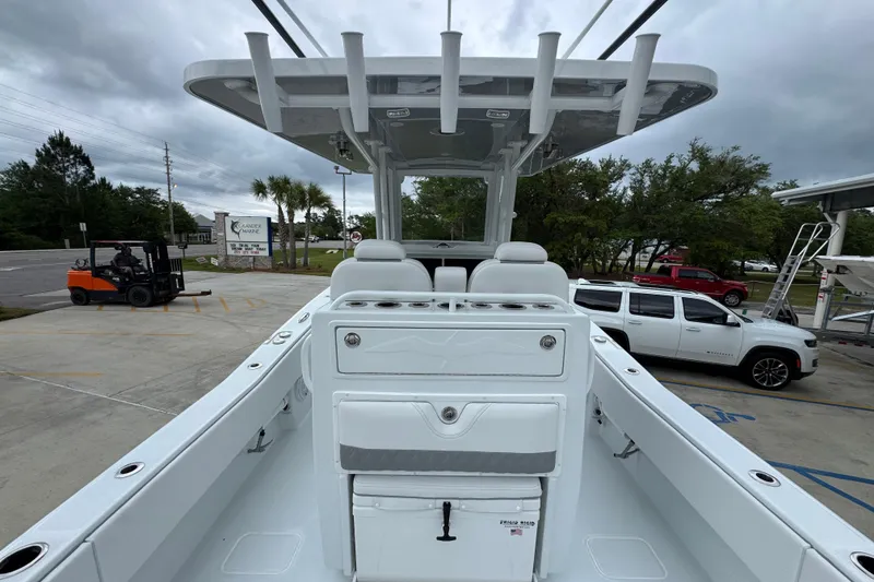 Slide: The Image of 2026 Invincible 33 Open Fisherman boat, docked with seating and storage, under cloudy skies. - 35