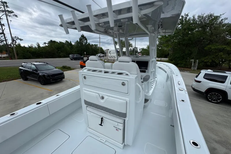 Slide: The Image of 2026 Invincible 33 Open Fisherman boat with sleek design, parked near vehicles. - 36