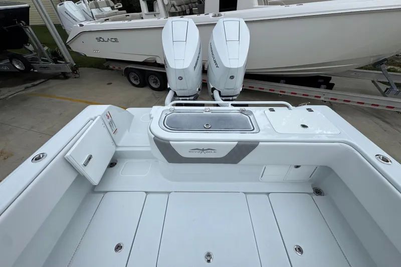 Slide: The Image of 2026 Invincible 33 Open Fisherman boat with dual Mercury engines, docked beside another vessel. - 38