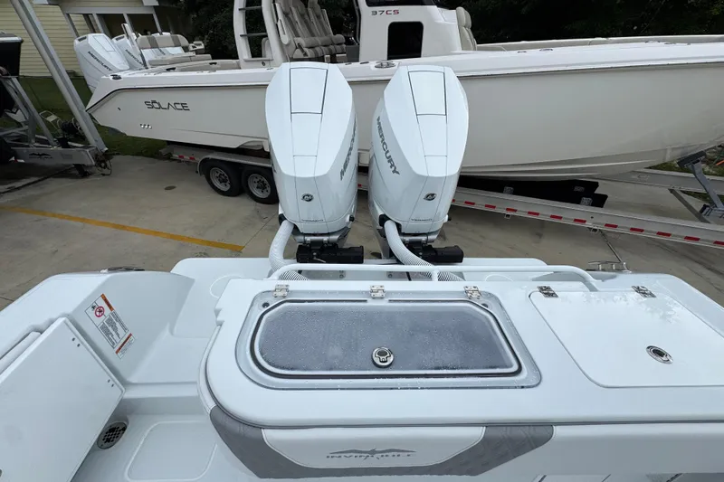Slide: The Image of 2026 Invincible 33 Open Fisherman boat with dual Mercury engines, docked beside another vessel. - 39