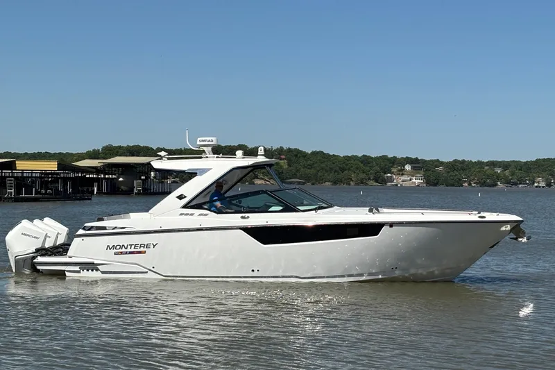 The Image of 2023 Monterey 385SS Super Sport boat on a calm lake under clear blue skies. - 1