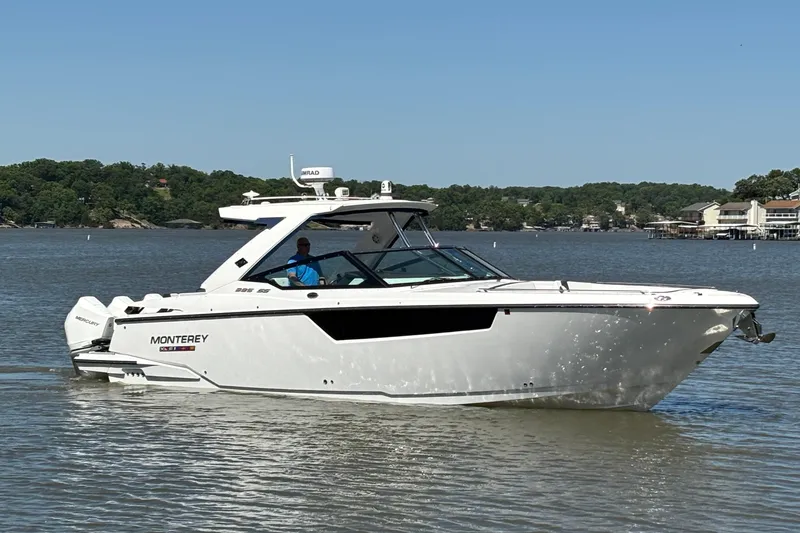 Slide: The Image of 2023 Monterey 385SS Super Sport boat cruising on a lake under clear blue skies. - 2