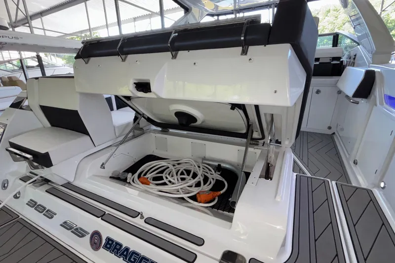 Slide: The Image of 2023 Monterey 385SS Super Sport boat with open storage compartment and coiled hose. - 27