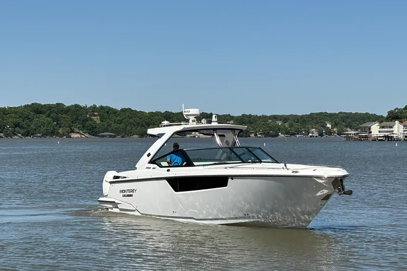 Slide: The Image of 2023 Monterey 385SS Super Sport boat cruising on a lake under clear blue skies. - 3