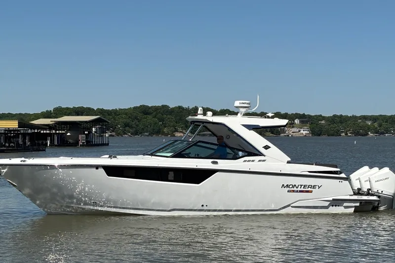 Slide: The Image of 2023 Monterey 385SS Super Sport boat cruising on a lake under clear skies. - 6