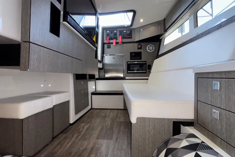 Slide: The Image of Interior of 2023 Monterey 385SS Super Sport boat, featuring modern seating and cabinetry. - 83