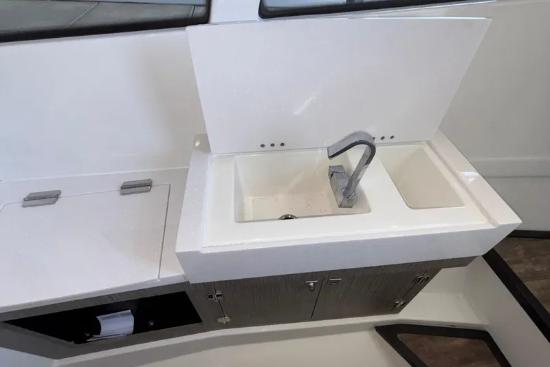 Slide: The Image of 2023 Monterey 385SS Super Sport boat sink with modern faucet and storage. - 90
