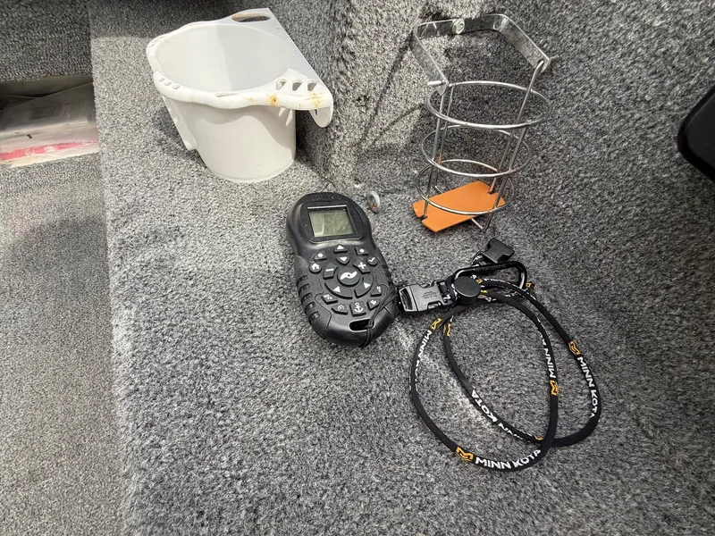 Slide: The Image of Interior of Alumacraft Navigator 175 CS boat with remote control and accessories. - 10