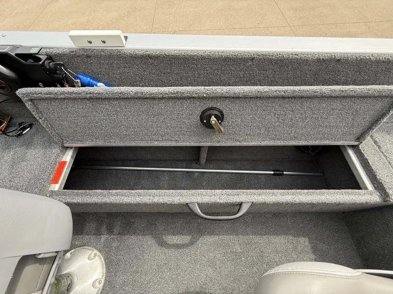 Slide: The Image of Alumacraft Navigator 175 CS 2010 boat storage compartment with gray carpet. - 28