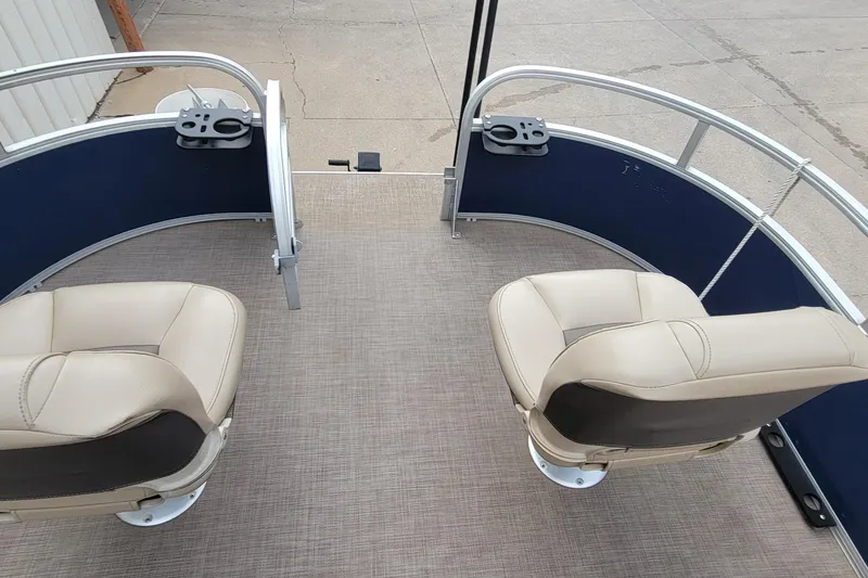 Slide: The Image of 2020 SUNTRACKER BASS BUGGY 16 XLS boat interior with two beige seats and blue railing. - 17