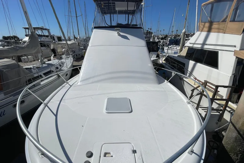 Slide: The Image of 2003 Luhrs 34 Convertible yacht docked at marina, surrounded by other boats. - 12