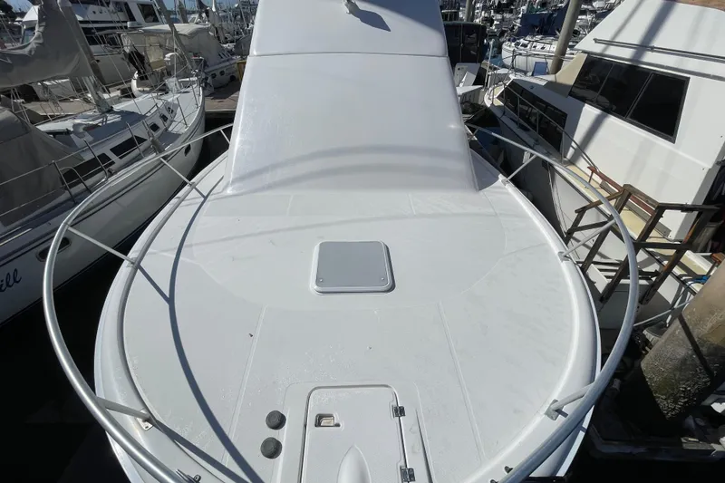 Slide: The Image of 2003 Luhrs 34 Convertible boat deck at marina, surrounded by other vessels. - 13