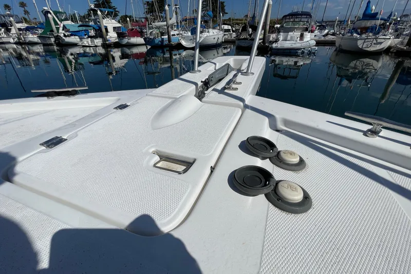 Slide: The Image of 2003 Luhrs 34 Convertible boat deck with marina view, featuring hatches and cleats. - 16