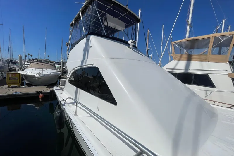 Slide: The Image of 2003 Luhrs 34 Convertible yacht docked at marina under clear blue sky. - 18