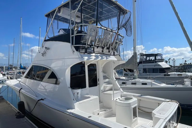 Slide: The Image of 2003 Luhrs 34 Convertible yacht docked at marina under clear blue sky. - 2