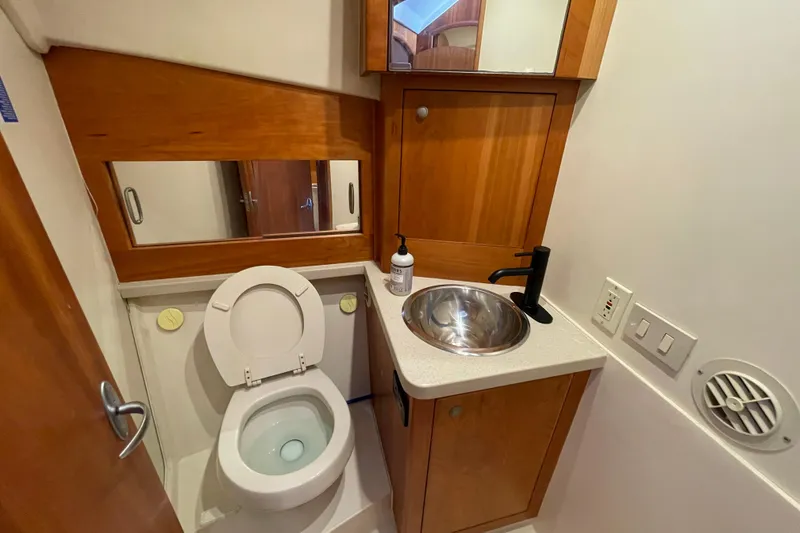 Slide: The Image of Compact bathroom in 2003 Luhrs 34 Convertible yacht with wooden cabinetry and stainless steel sink. - 27