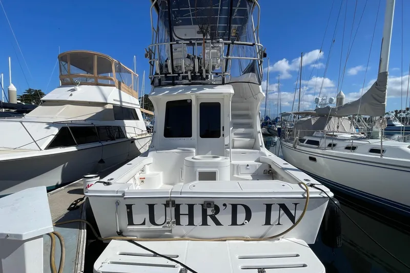 Slide: The Image of 2003 Luhrs 34 Convertible boat docked at marina under clear blue sky. - 3