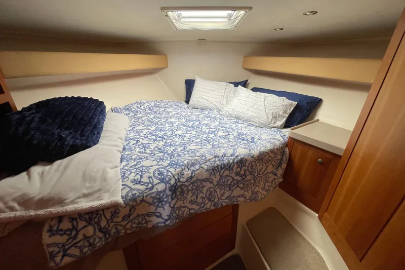 Slide: The Image of Cozy cabin interior of 2003 Luhrs 34 Convertible with nautical-themed bedding. - 30