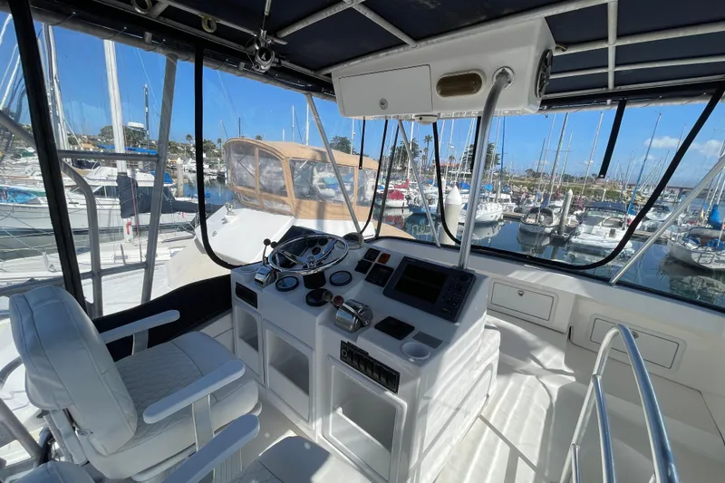 Slide: The Image of Helm of 2003 Luhrs 34 Convertible yacht with marina view. - 34