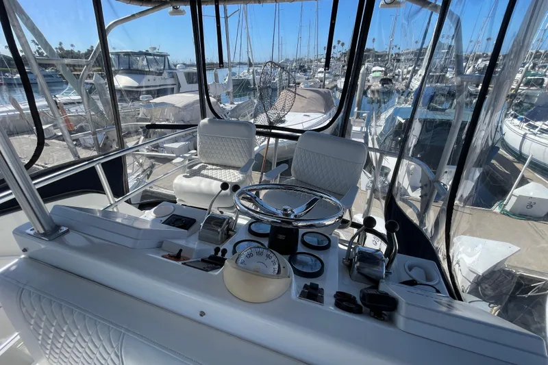 Slide: The Image of Helm of 2003 Luhrs 34 Convertible boat with marina view, featuring steering wheel and controls. - 35
