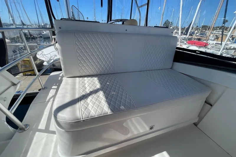 Slide: The Image of White cushioned seating on 2003 Luhrs 34 Convertible boat, docked at marina. - 46