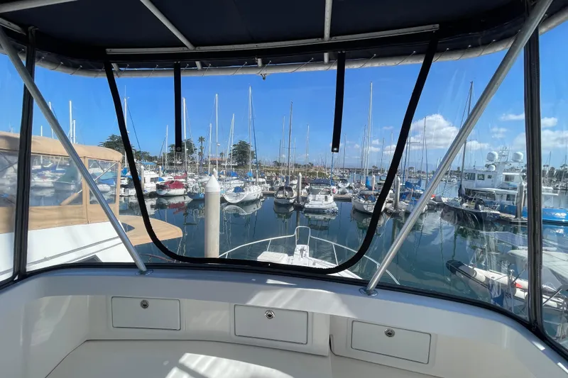 Slide: The Image of 2003 Luhrs 34 Convertible yacht view from cockpit, overlooking marina with sailboats. - 48