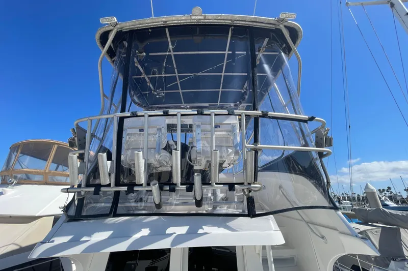 Slide: The Image of 2003 Luhrs 34 Convertible yacht with enclosed flybridge, docked under clear blue sky. - 5