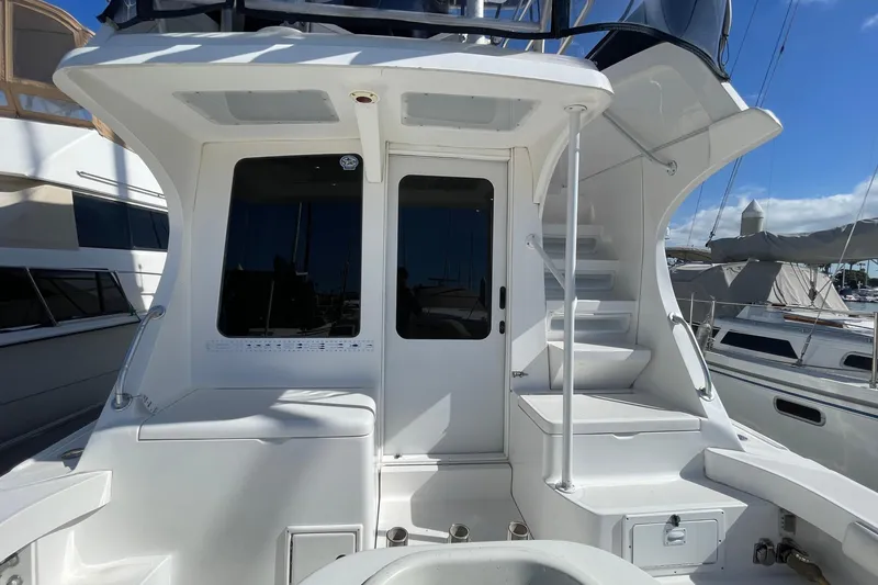 Slide: The Image of 2003 Luhrs 34 Convertible yacht stern view with stairs and door, docked at marina. - 6