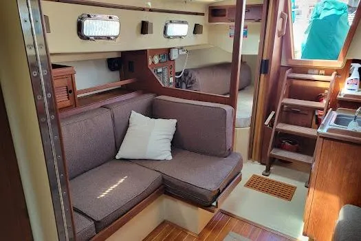 Slide: The Image of Interior of 1988 Island Packet 31 sailboat with cozy seating and wooden accents. - 18