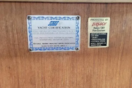 Slide: The Image of 1988 Island Packet 31 yacht certification and Fireboy Halon 1301 fire system labels. - 35