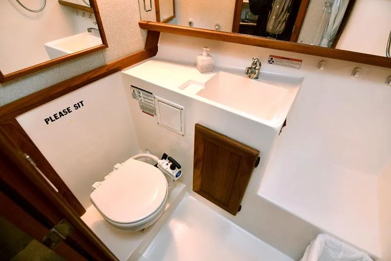 Slide: The Image of Bathroom interior of 1993 Bayliner 3288 Motoryacht with toilet, sink, and wooden cabinet. - 12
