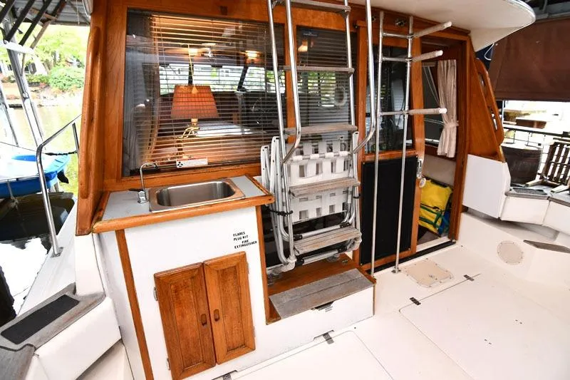Slide: The Image of 1993 Bayliner 3288 Motoryacht interior with sink, wooden cabinetry, and ladder. - 4