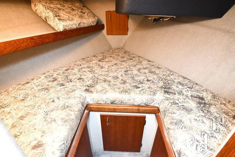 Slide: The Image of 1993 Bayliner 3288 Motoryacht cabin interior with patterned bedding and wooden storage. - 9