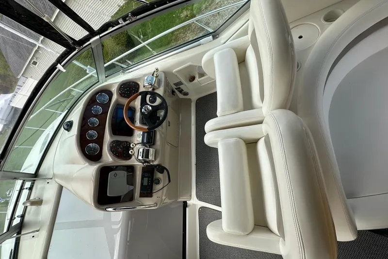 Slide: The Image of 2003 Sea Ray 340 Sundancer helm with white seating and modern controls. - 11