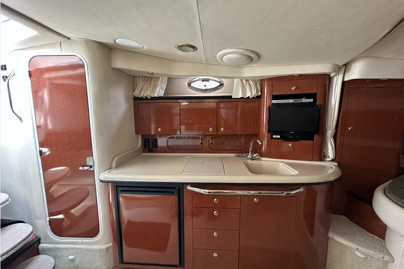 Slide: The Image of Interior of 2003 Sea Ray 340 Sundancer yacht, featuring kitchenette and cabinetry. - 17
