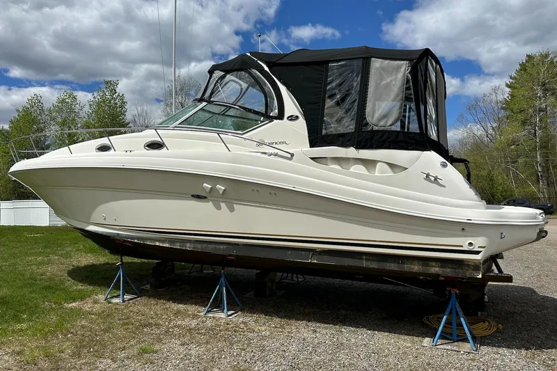 Slide: The Image of 2003 Sea Ray 340 Sundancer boat on stands, outdoors under a partly cloudy sky. - 5