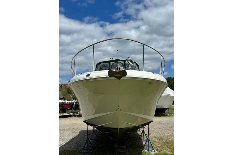 Slide: The Image of 2003 Sea Ray 340 Sundancer boat on stands, under a partly cloudy sky. - 6