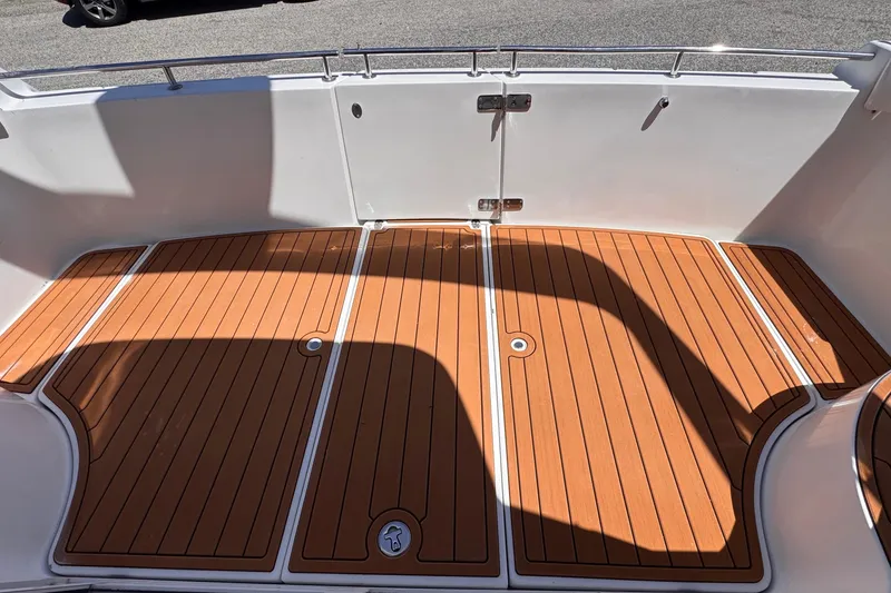 Slide: The Image of 2006 Carver 36 Mariner boat deck with teak flooring and stainless steel railing. - 15
