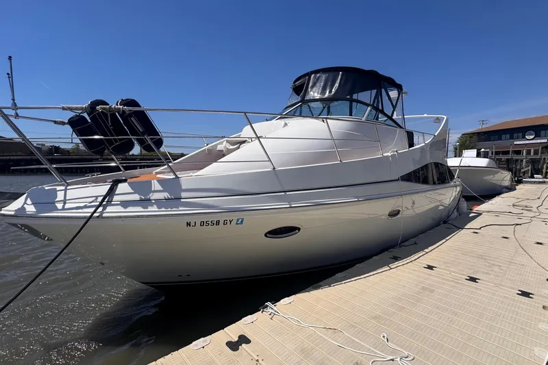 Slide: The Image of 2006 Carver 36 Mariner yacht docked at marina under clear blue sky. - 2
