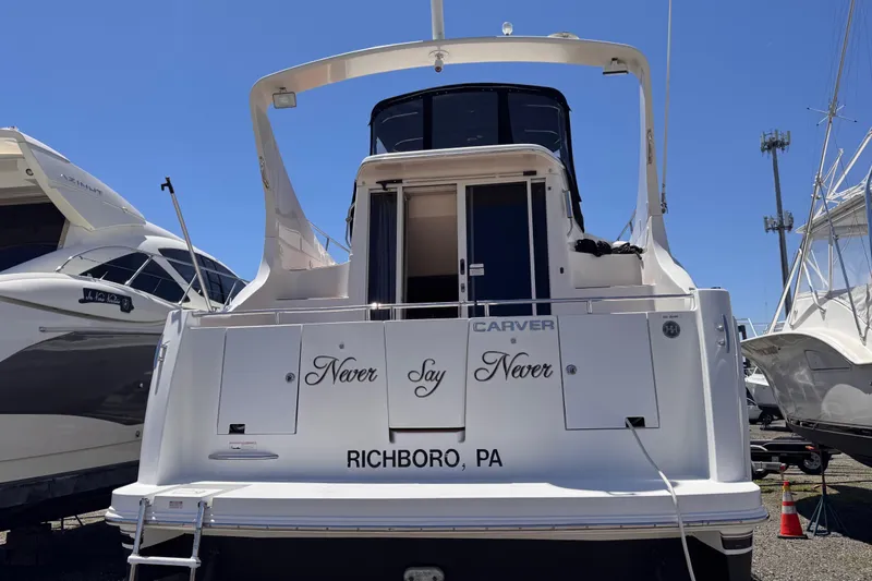 Slide: The Image of 2006 Carver 36 Mariner yacht docked, rear view, with "Never Say Never" text. - 4