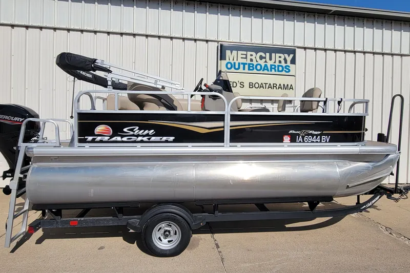 The Image of 2022 SUNTRACKER BASS BUGGY 16 XLS pontoon boat on trailer, parked outside dealership. - 0