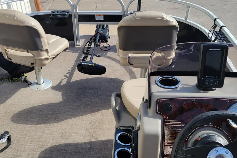Slide: The Image of 2022 SUNTRACKER BASS BUGGY 16 XLS interior with seats, steering, and fishfinder. - 17