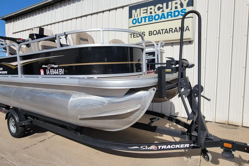 Slide: The Image of 2022 SUNTRACKER BASS BUGGY 16 XLS pontoon boat on trailer at dealership. - 2