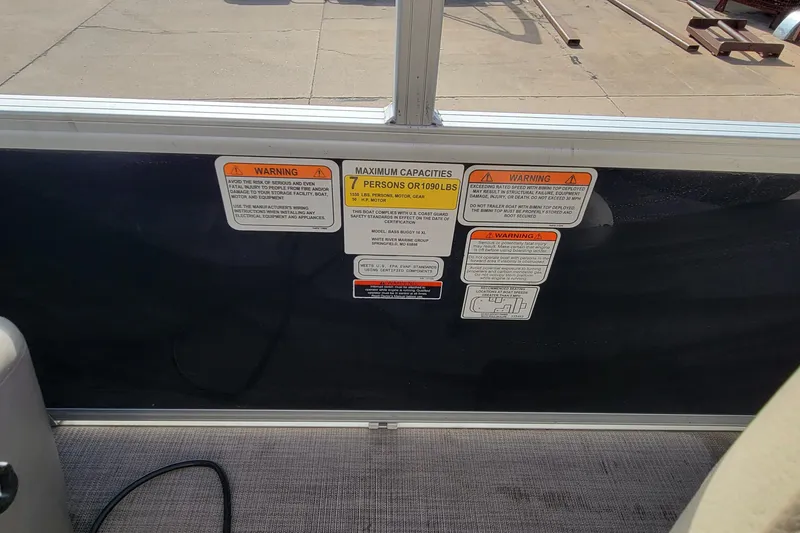 Slide: The Image of 2022 SUNTRACKER BASS BUGGY 16 XLS capacity warning labels on boat interior. - 21