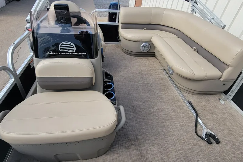 Slide: The Image of 2022 SUNTRACKER BASS BUGGY 16 XLS interior with beige seating and steering console. - 31