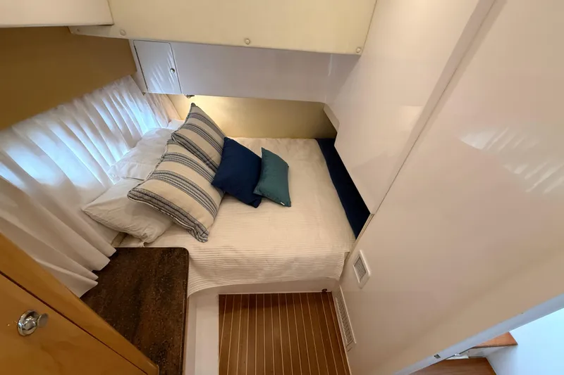 Slide: The Image of Cozy cabin interior of 2016 Intrepid 430 Sport Yacht with striped pillows and wooden flooring. - 11
